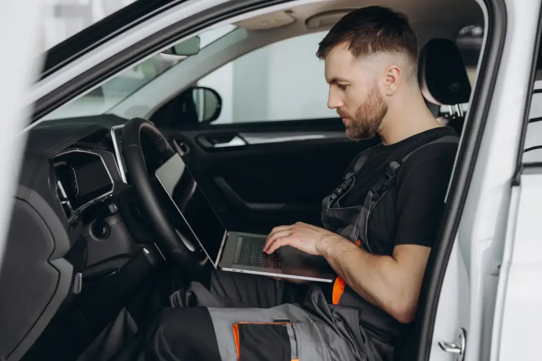 Technician using a laptop inside a vehicle