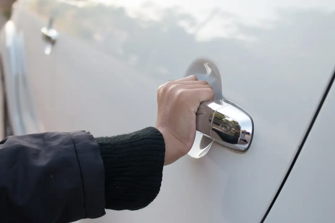 Hand opening a car door after a non-destructive vehicle entry