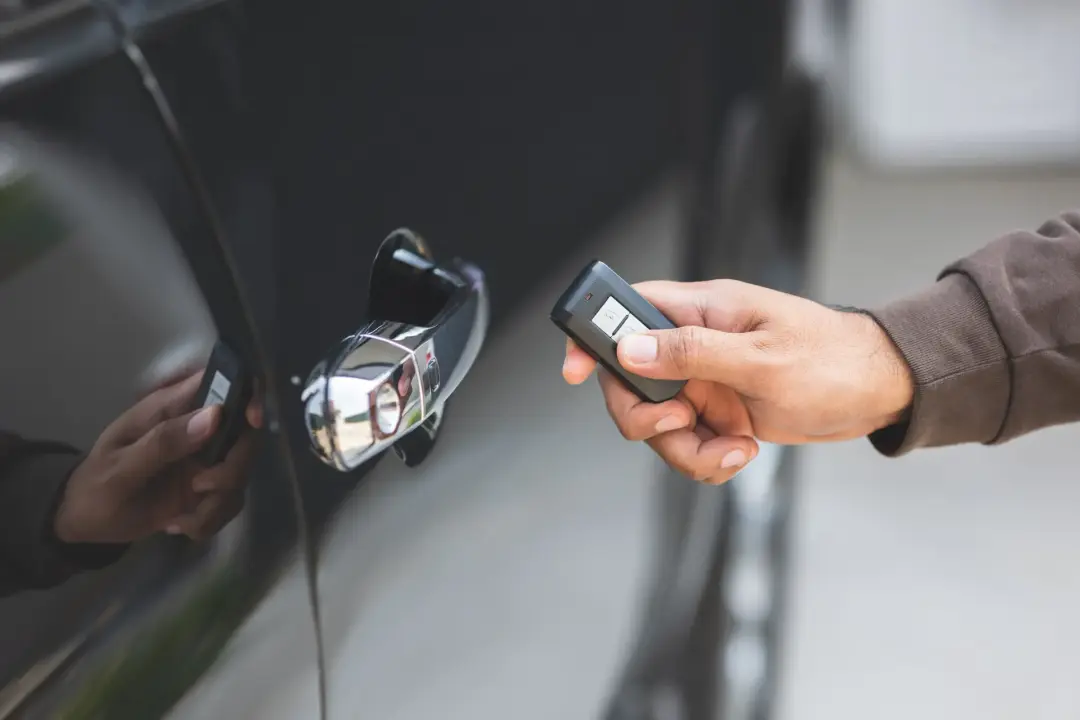 Person using a remote key beside a vehicle
