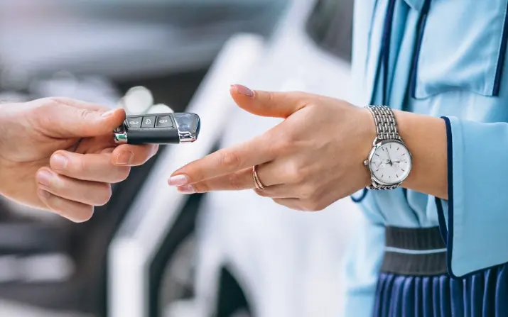 Technician handing a car key to a customer
